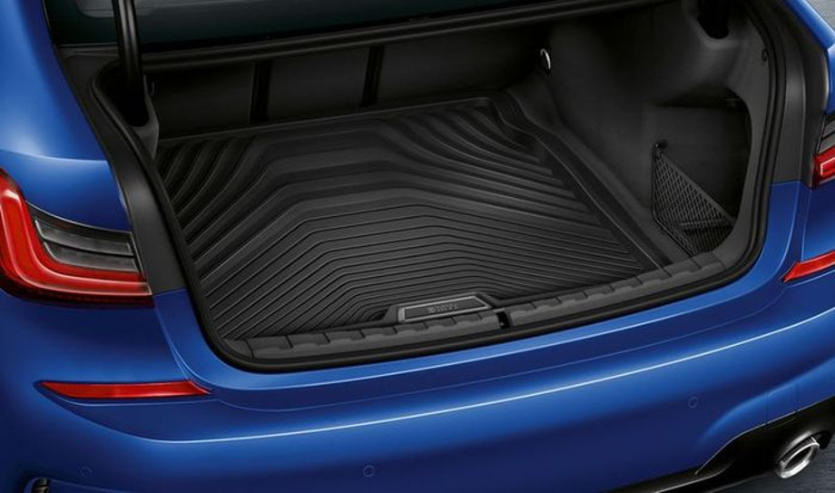 На фото в автомобілі BMW 3 G20 яскраво-синього кольору відкритий багажник з килимком поліуретановим.